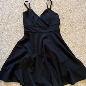 Black mini dress. Adjustable sleeves. Detail around waist